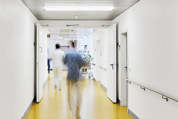 Krankenhausflur, in dem Personen verwischt zu sehen sind